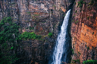 Tall waterfall cascading down rugged cliff face