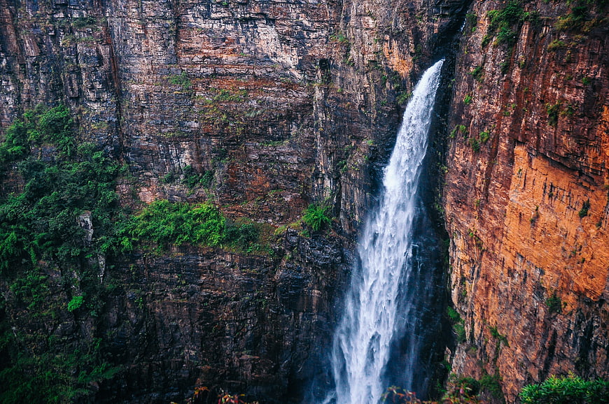 Tall waterfall cascading down rugged cliff face
