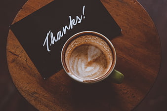 Top View of Coffee Cup and Black Thanks Card on Wooden Table