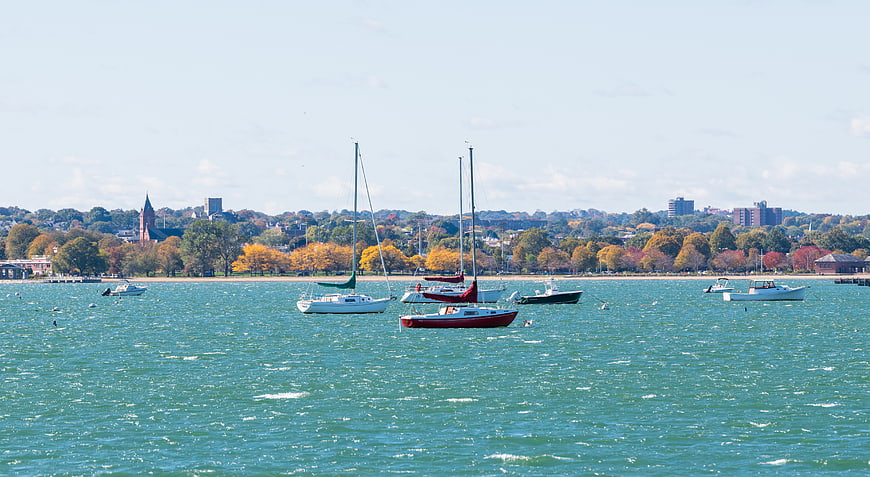 Sailboats Anchored in Harbor with Autumn City Skyline