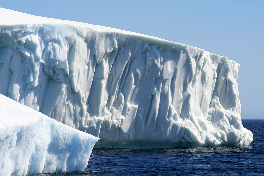 Massive Tabular Iceberg Floating in Deep Blue Ocean