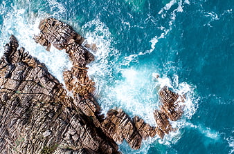 Aerial View of Turquoise Ocean Waves Crashing on Rocky Coast