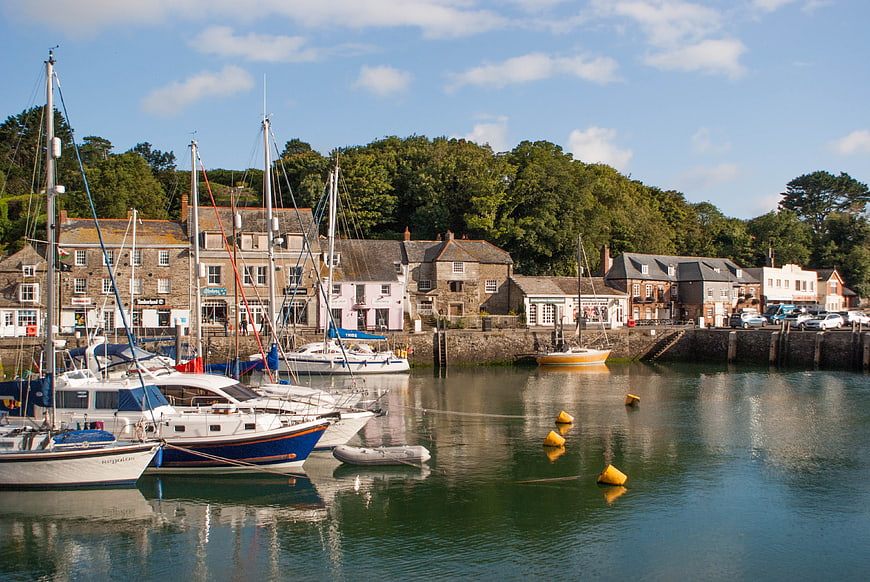 Sailboats docked in a picturesque coastal harbor town