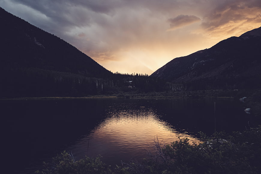Dramatic sunset reflection on calm mountain lake