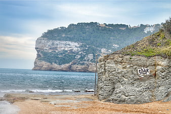 Rugged coastal cliffs overlooking a sandy beach and ocean