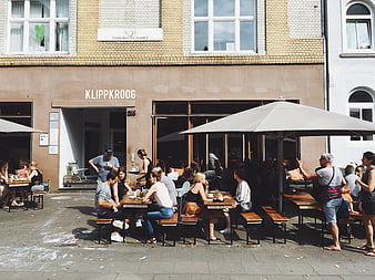 People dining at outdoor cafe terrace in city street