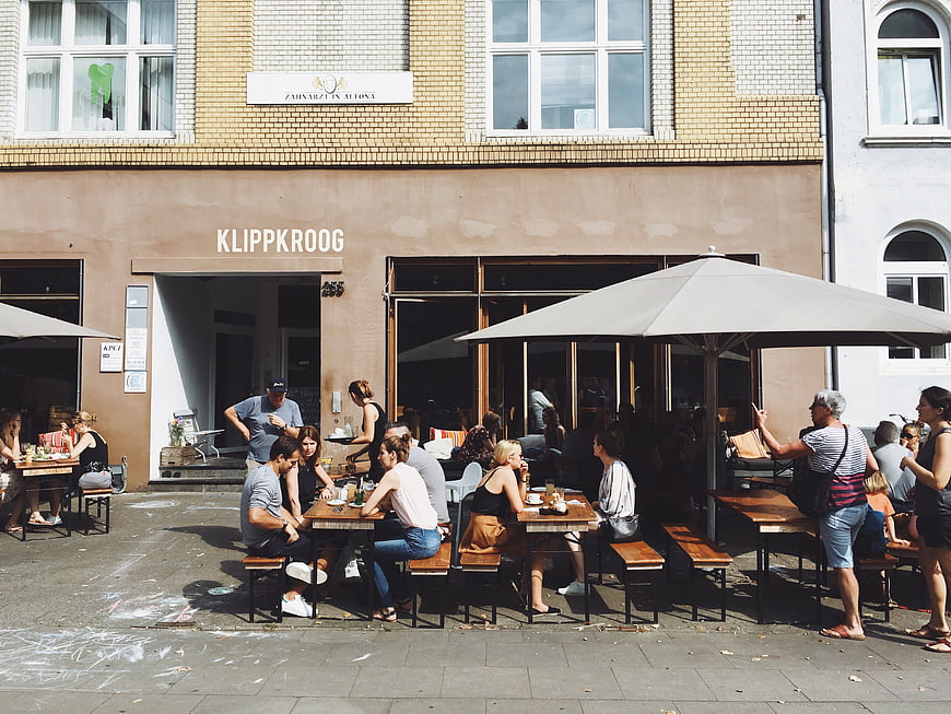 People dining at outdoor cafe terrace in city street