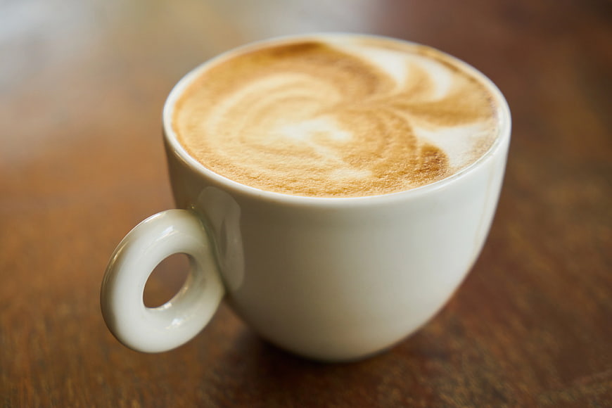 Close-up of Cappuccino with Latte Art on Wooden Table