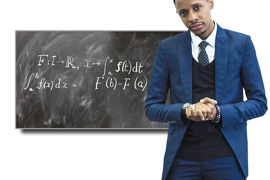 Young male professor checking watch near calculus chalkboard