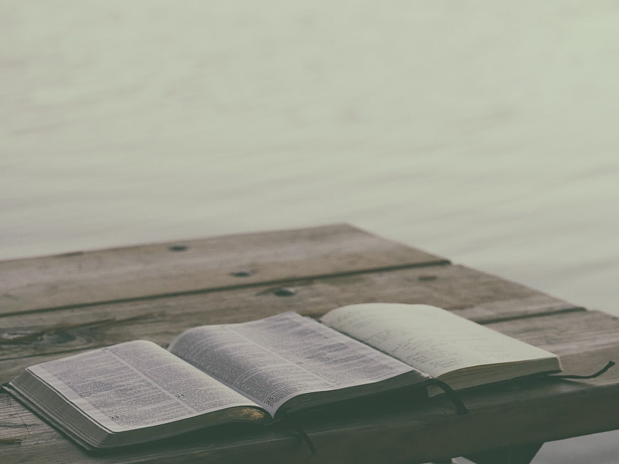 Open Bible on Wooden Dock by Lake