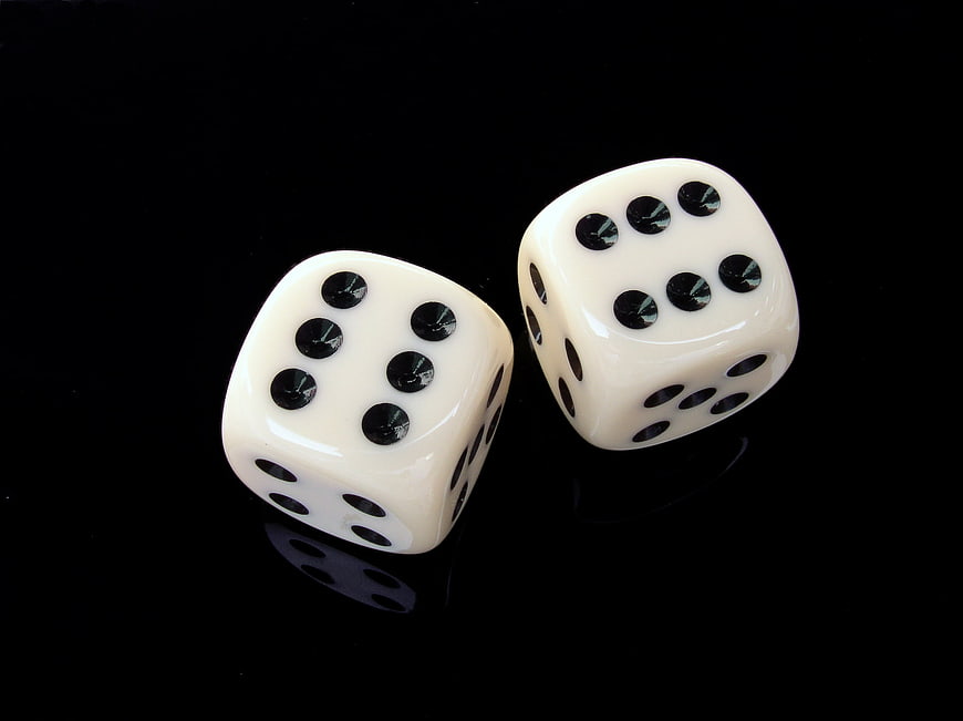 Two white dice showing six on black background