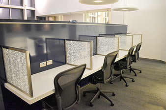 Modern office workspace with mesh dividers and ergonomic chairs