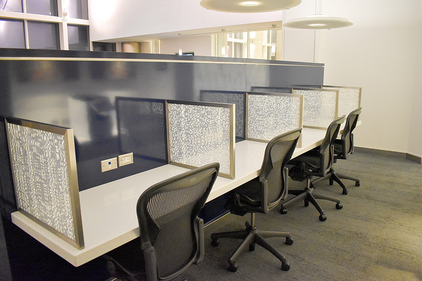 Modern office workspace with mesh dividers and ergonomic chairs