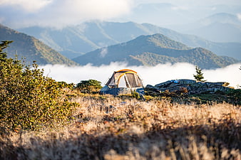 Camping Tent on Mountain Ridge Above Sea of Clouds