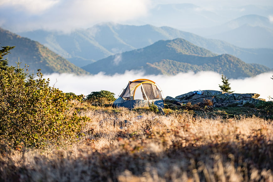 Camping Tent on Mountain Ridge Above Sea of Clouds
