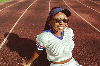 Smiling Black Woman in Sporty Fashion on Running Track