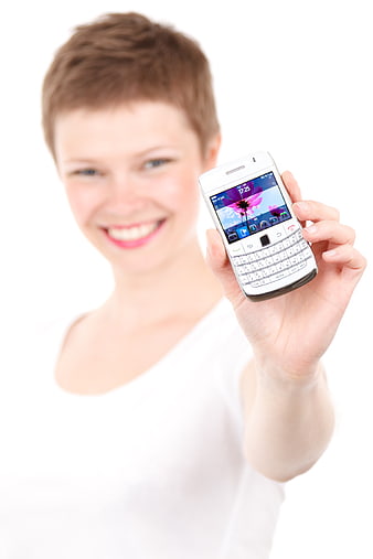 Young woman holding white smartphone with physical keyboard