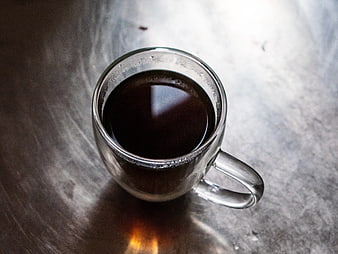 Top View of Black Coffee in Clear Glass Mug on Metal Surface