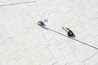 Aerial view of people relaxing on white tiled plaza