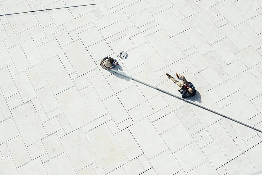 Aerial view of people relaxing on white tiled plaza
