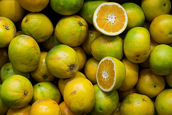 Fresh Green Oranges and Cut Citrus Fruit Close-Up