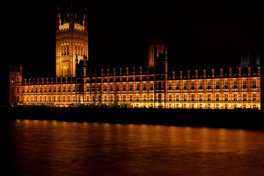 Illuminated Palace of Westminster at Night with River Thames Reflection