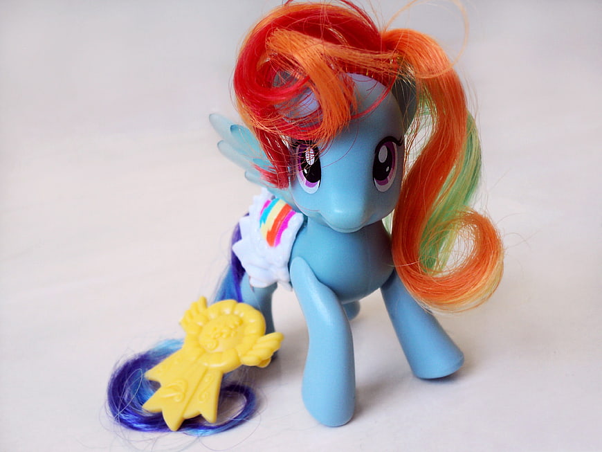 Blue My Little Pony toy with rainbow mane and yellow accessory