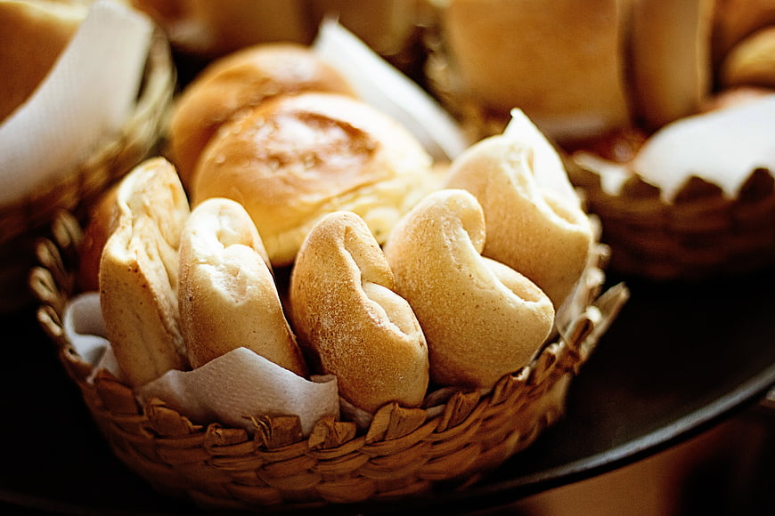 Freshly baked bread rolls in a woven basket
