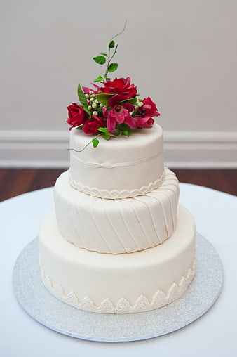 Elegant Three-Tier White Wedding Cake with Red Flowers