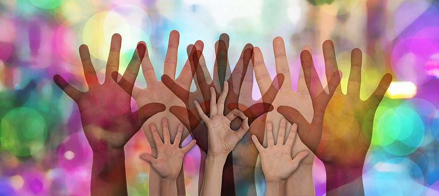 Diverse Hands Raised Together Against Colorful Bokeh Background