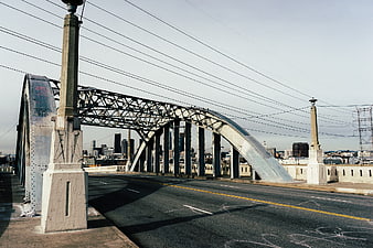 Steel Arch Bridge with City Skyline Background