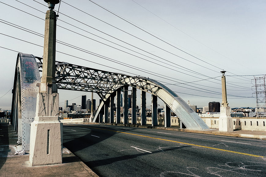 Steel Arch Bridge with City Skyline Background
