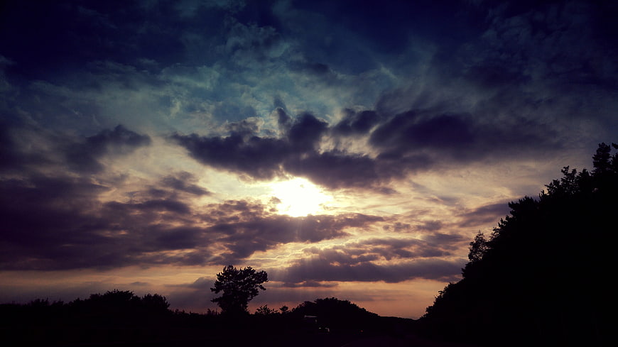 Dramatic Sunset Sky with Sun Rays Through Clouds