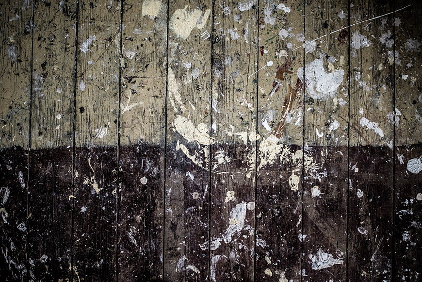 Grungy wooden texture with paint splatters and peeling layers