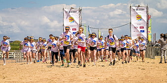 Group of young runners starting a beach marathon event