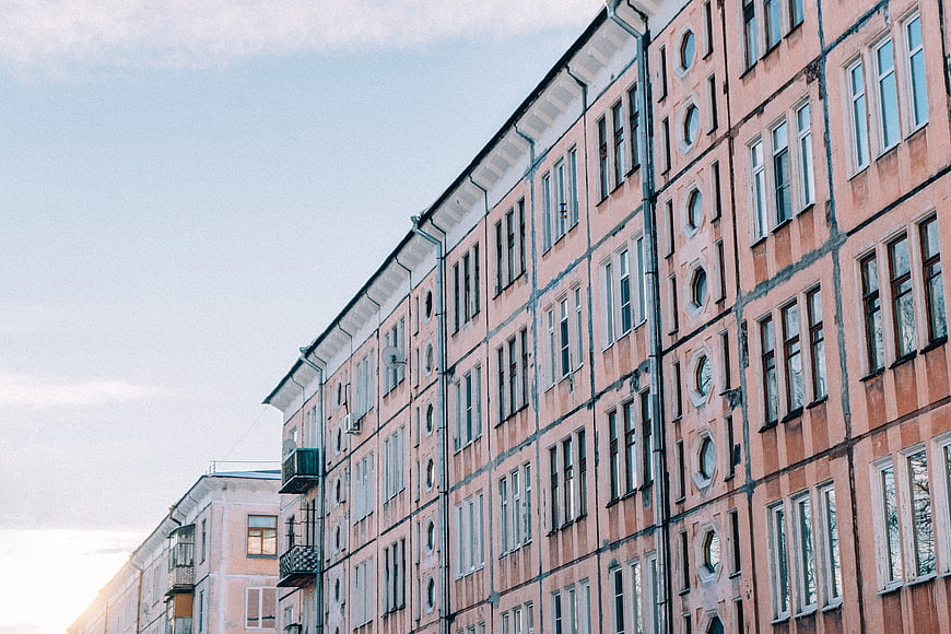 Low angle view of pink apartment building facade