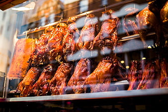 Glossy Roasted Ducks Hanging in a Glass Display Case