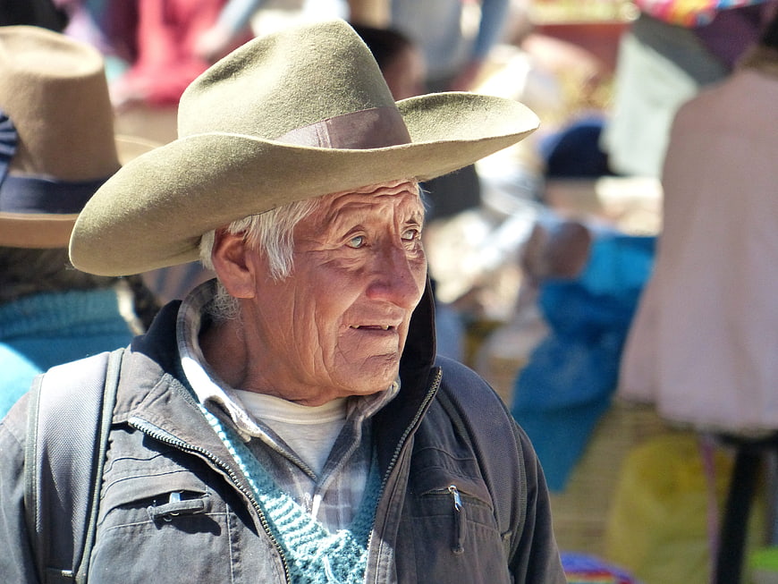 Portrait of elderly man in wide-brimmed hat at outdoor market