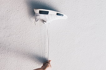 Hand Pulling White Sneaker Laces Against Textured Wall