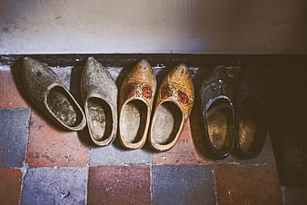 Vintage wooden clogs on tiled floor
