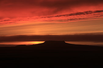 Dramatic red sunset over silhouetted Icelandic volcano crater