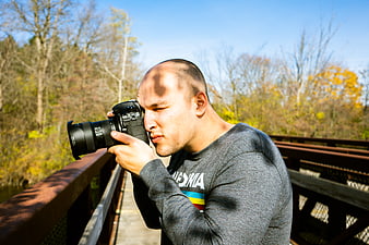 Male Photographer Taking Pictures on a Bridge