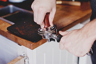 Barista Tamping Espresso Coffee Grounds in Portafilter