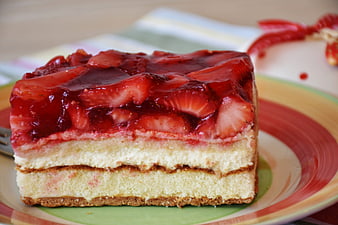 Close-up of layered strawberry cream cake slice on colorful plate
