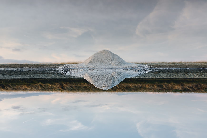 Surreal Sand Dune Reflection in Calm Lake Water