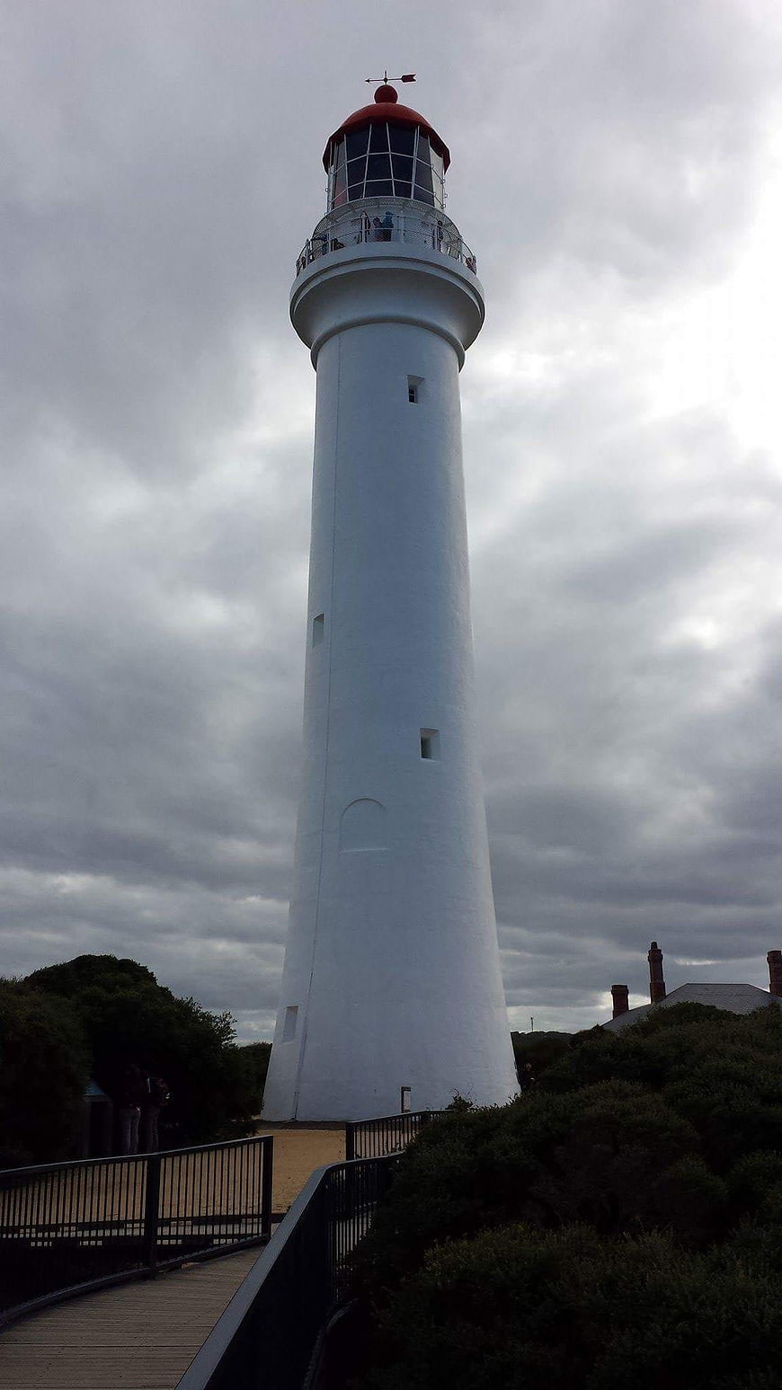 White Lighthouse Tower Against Dramatic Cloudy Sky
