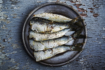 Grilled sardines on rustic metal plate