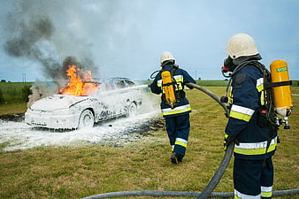 Firefighters Extinguishing Burning Car with Foam