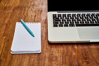 Laptop, Notepad, and Pen on Wooden Desk Workspace