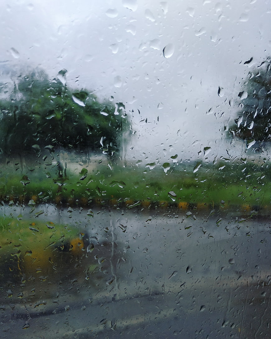 Raindrops on Window Glass with Blurred Green Background